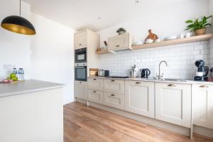 a kitchen with white cabinets and a sink at End House Inverness in Inverness