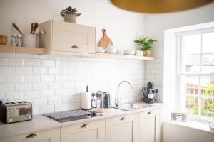 a white kitchen with a sink and a microwave at End House Inverness in Inverness +13 photos