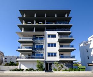 an apartment building with balconies on a city street at Solaar Apartments Faneromeni in Larnaca