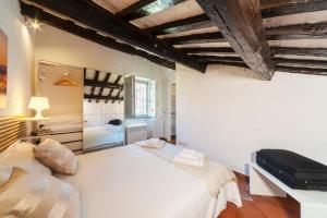 een slaapkamer met een groot wit bed en zichtbare plafonds bij Cozy & Charme Apartment in Rome in Rome