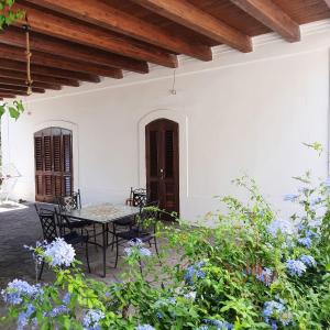 - une terrasse avec une table, des chaises et des fleurs dans l'établissement Casa Schicciola, à Stromboli