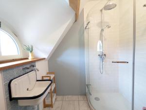 uma casa de banho com um lavatório e um chuveiro em Maison typique bretonne avec toit de chaume em Camors