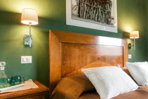 łóżko z drewnianym zagłówkiem w zielonej sypialni w obiekcie Agriturismo Terrerosse Di Massadita w mieście Aieta