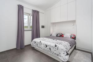 sypialnia z dużym łóżkiem i oknem w obiekcie Gallery apartment in Skrbcici (Krk) w mieście Skrbčići
