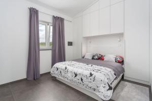 a bedroom with a large bed and a window at Gallery apartment in Skrbcici (Krk) in Skrbčići