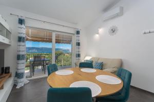 jadalnia z drewnianym stołem i krzesłami w obiekcie Gallery apartment in Skrbcici (Krk) w mieście Skrbčići