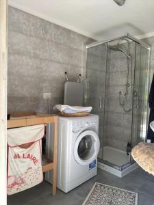 uma casa de banho com uma máquina de lavar roupa e um chuveiro em villa marcella casa vacanza em Grottazzolina