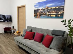sala de estar con sofá gris y almohadas rojas en PRAGUE’s HIDDEN PEARL, en Praga