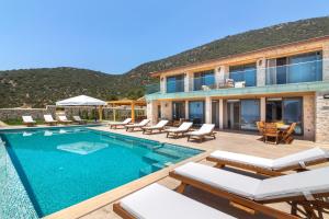 a villa with a swimming pool and patio furniture at Water Edge 1 in Kaş