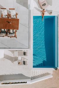 a person jumping into the water from a swimming pool at Sunsenses villa Ariadne in Piso Livadi