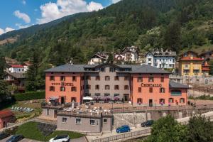 ein Hotel in einer Stadt mit einem Berg im Hintergrund in der Unterkunft Hotel Garni Cristallo in Ponte di Legno