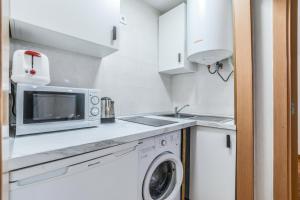 uma cozinha com um micro-ondas e uma máquina de lavar roupa em Collection Plaza de España em Madri
