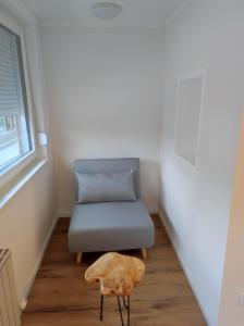 a chair and a stool in a room with a window at Sommerresidenz 9210 in Pörtschach am Wörthersee