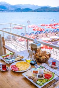 a table with breakfast foods and a view of the water at Olympos Mocamp in Kaş