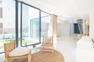 um quarto com uma cama e uma cadeira e janelas amplas em Villa Melissa em Tróia