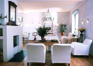a living room with white chairs and a fireplace at Seehotel Am Neuklostersee in Neukloster