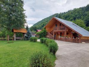 a large wooden cabin in a field of grass at Green Eden Lepsa 2 in Lepşa