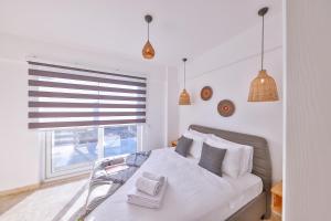 a bedroom with a white bed with a window at Villa Ay in Kaş