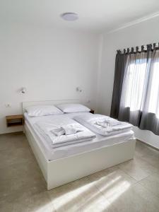 a white bed in a white room with windows at Tisa Homes in Savudrija