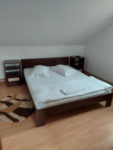 a bed in a bedroom with a wooden headboard at Green Eden Lepsa 2 in Lepşa