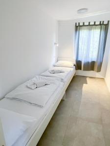 un letto bianco in una stanza con finestra di Tisa Homes a Savudrija