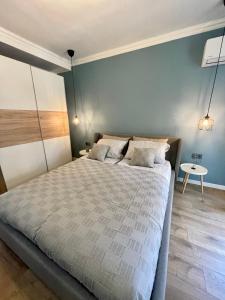 a bedroom with a large bed and a blue wall at Chernomorets Apartment in Chernomorets