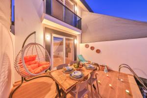 a room with a table and a swinging chair at Villa Ay in Kaş