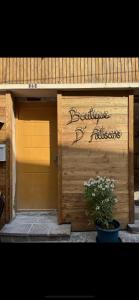 una puerta de madera con un letrero. en Magnifique Loft Balnéo Hammam #3, en Embrun