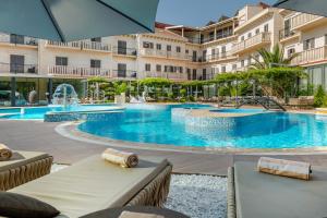 een zwembad in een hotel met stoelen en een parasol bij Hotel President Solin in Solin +51 foto's