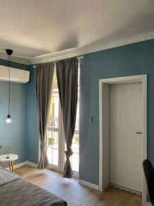 a bedroom with blue walls and a sliding glass door at Chernomorets Apartment in Chernomorets