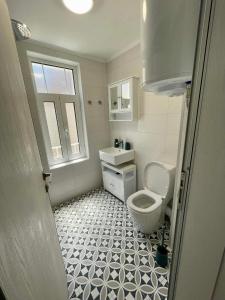 a white bathroom with a toilet and a sink at Chernomorets Apartment in Chernomorets