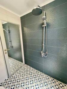 a shower in a bathroom with a blue wall at Chernomorets Apartment in Chernomorets