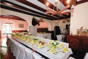 a long table in a room with white tables and chairs at Rittergut Schloss Niederforchheim in Forchheim