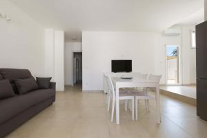 uma sala de estar com uma mesa branca e um sofá em Residence Marelena by BarbarHouse em Casalabate
