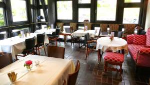 a dining room with tables and chairs and tablesearcher at Meyers Hotel Hittfeld in Seevetal