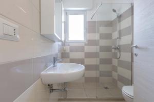 uma casa de banho com um lavatório, um chuveiro e um WC. em Residence Marelena by BarbarHouse em Casalabate