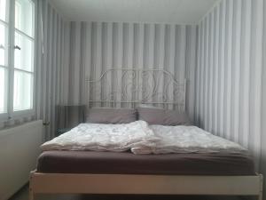 a bedroom with a white bed with a metal headboard at Ferienwohnung zur Kühlung in Wittenbeck