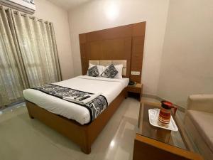 a bedroom with a bed and a coffee table at hotel green city in Chennai
