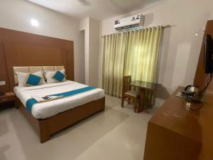 a bedroom with a bed and a table and a window at hotel green city in Chennai