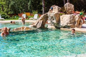 un grupo de personas nadando en una piscina en Costa Rica Bibione Eco Resort en Bibione