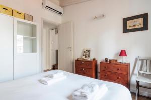 ein Schlafzimmer mit einem weißen Bett und einer Holzkommode in der Unterkunft LUVI - Adda in Mailand