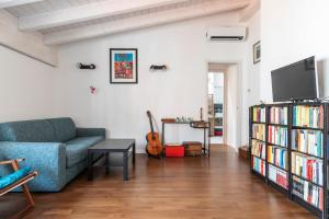 ein Wohnzimmer mit einem Sofa und einem Bücherregal mit Büchern in der Unterkunft LUVI - Adda in Mailand