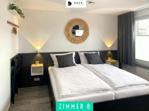 a bedroom with a large bed and a mirror at Dock 6 - Cuxhaven in Cuxhaven