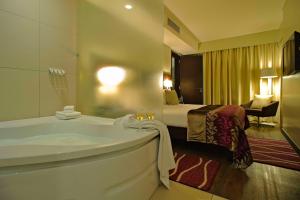 a hotel room with a tub and a bed at Eka Hotel Nairobi in Nairobi