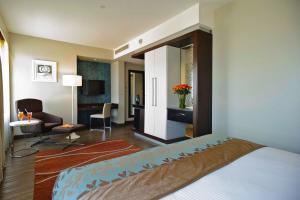 a hotel room with a bed and a living room at Eka Hotel Nairobi in Nairobi