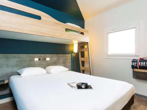 una camera con un letto bianco e una parete blu di ibis budget Paris Porte d'Italie Est a Le Kremlin-Bicêtre