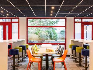 a restaurant with colorful chairs and a table at ibis budget Paris Porte d'Italie Est in Le Kremlin-Bicêtre