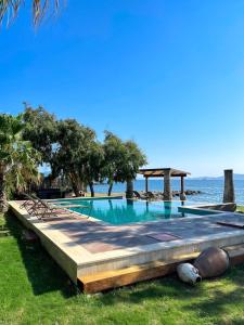 a swimming pool with the ocean in the background at Villa Di Mare Bodrum in Bodrum City