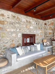a couch in a room with a stone wall at Villa Di Mare Bodrum in Bodrum City