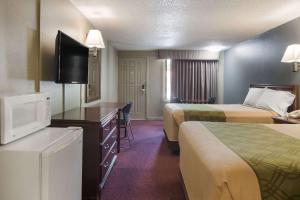 a hotel room with two beds and a flat screen tv at Econo Lodge Pittsburgh I-79 in Pittsburgh